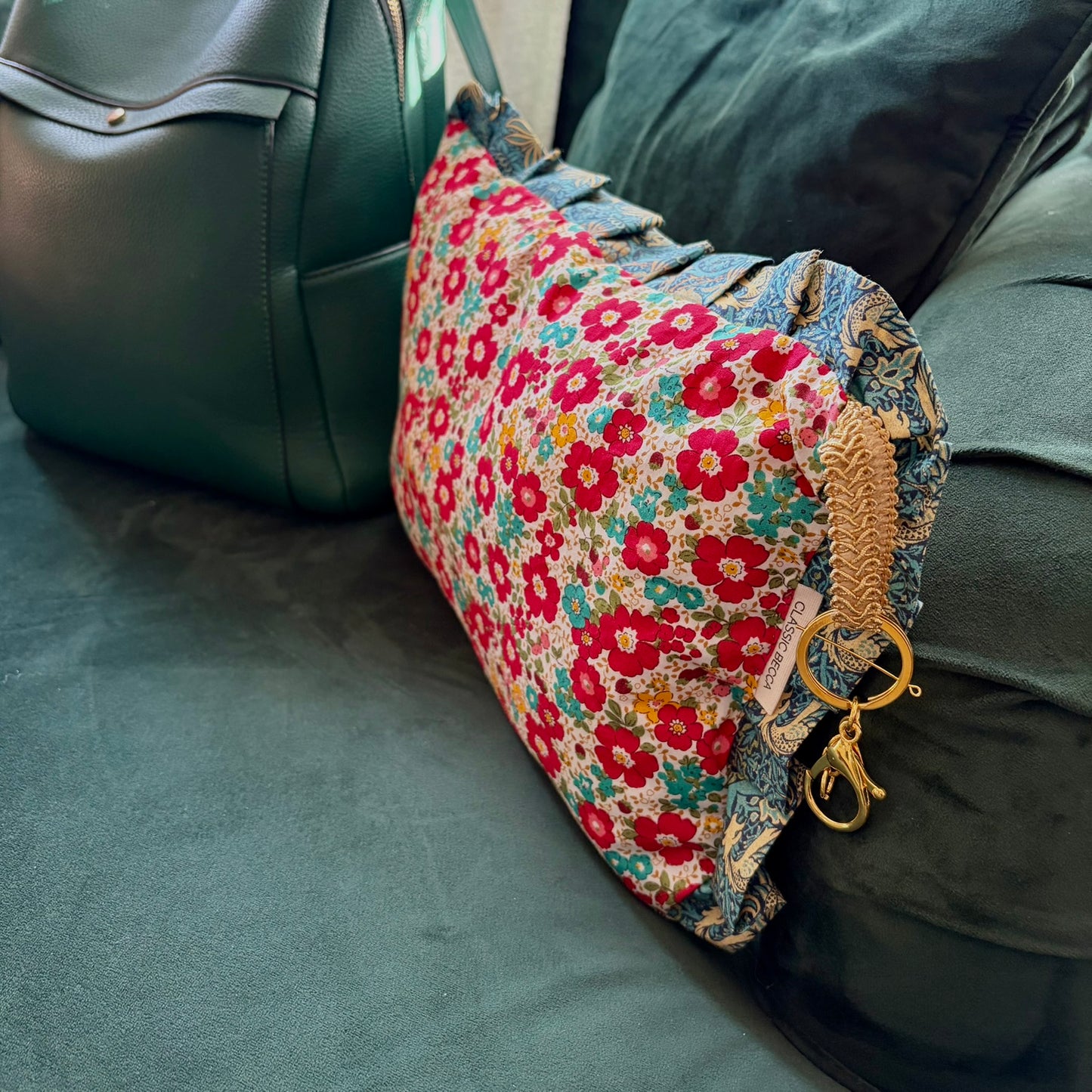 Floral-patterned cushion with a keychain on a green surface